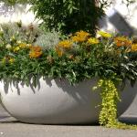 Eternit Lausanne Pflanzengefäß in natur Grau mit bunten Blumen